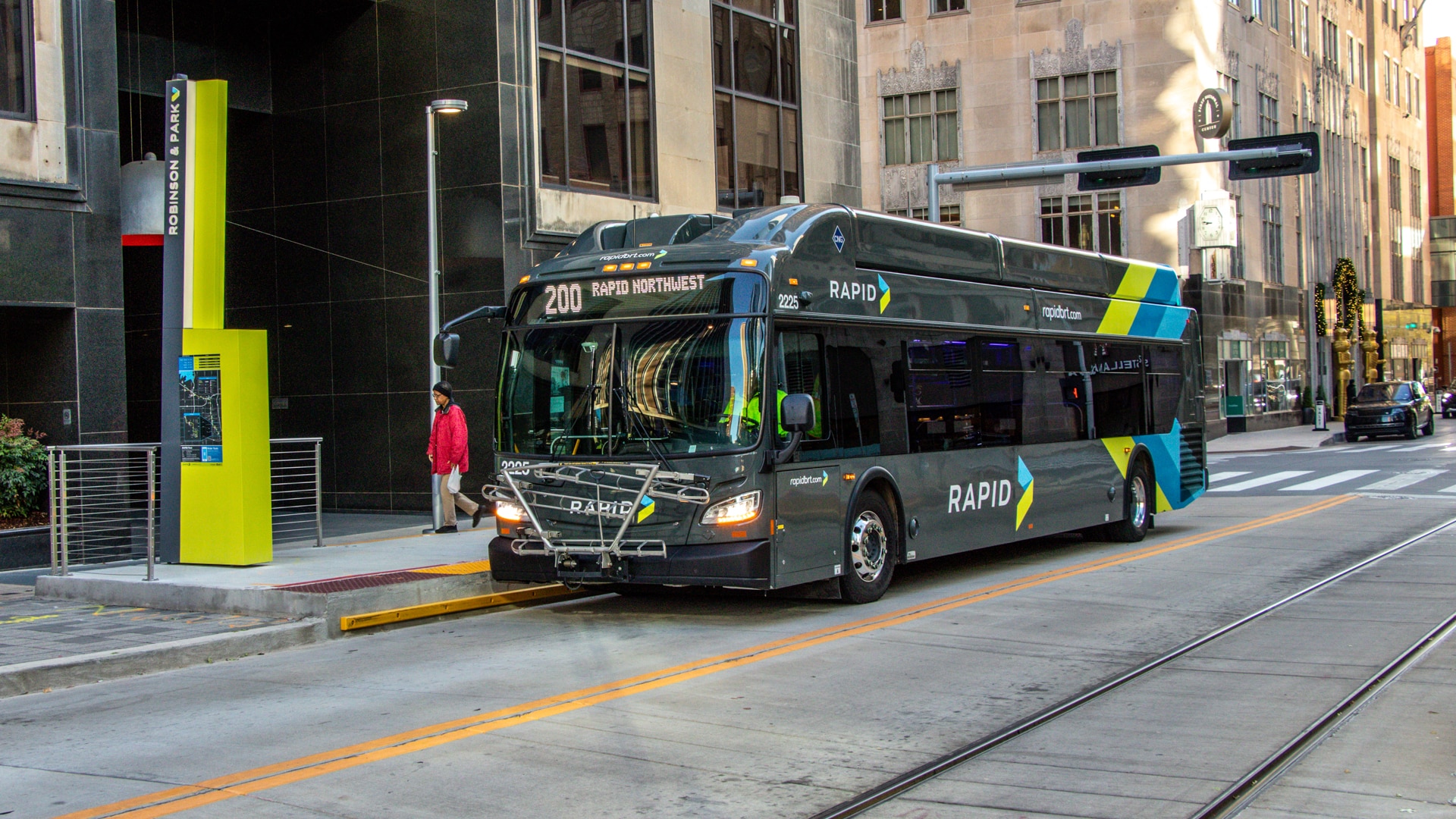 An EMBARK RAPID rebranded bus driving down a city street.