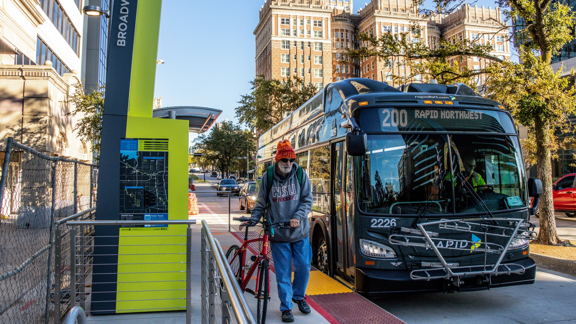 An EMBARK RAPID rebranded bus letting someone off at their city stop.