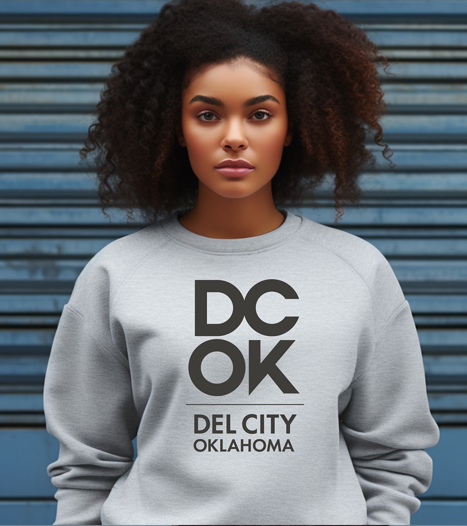 The Del City logo mocked up on a sweatshirt on a young woman.