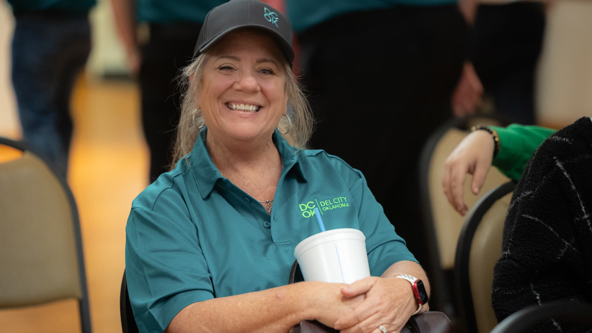 A Del City staff member proudly wears the new branding on a polo shirt and hat.