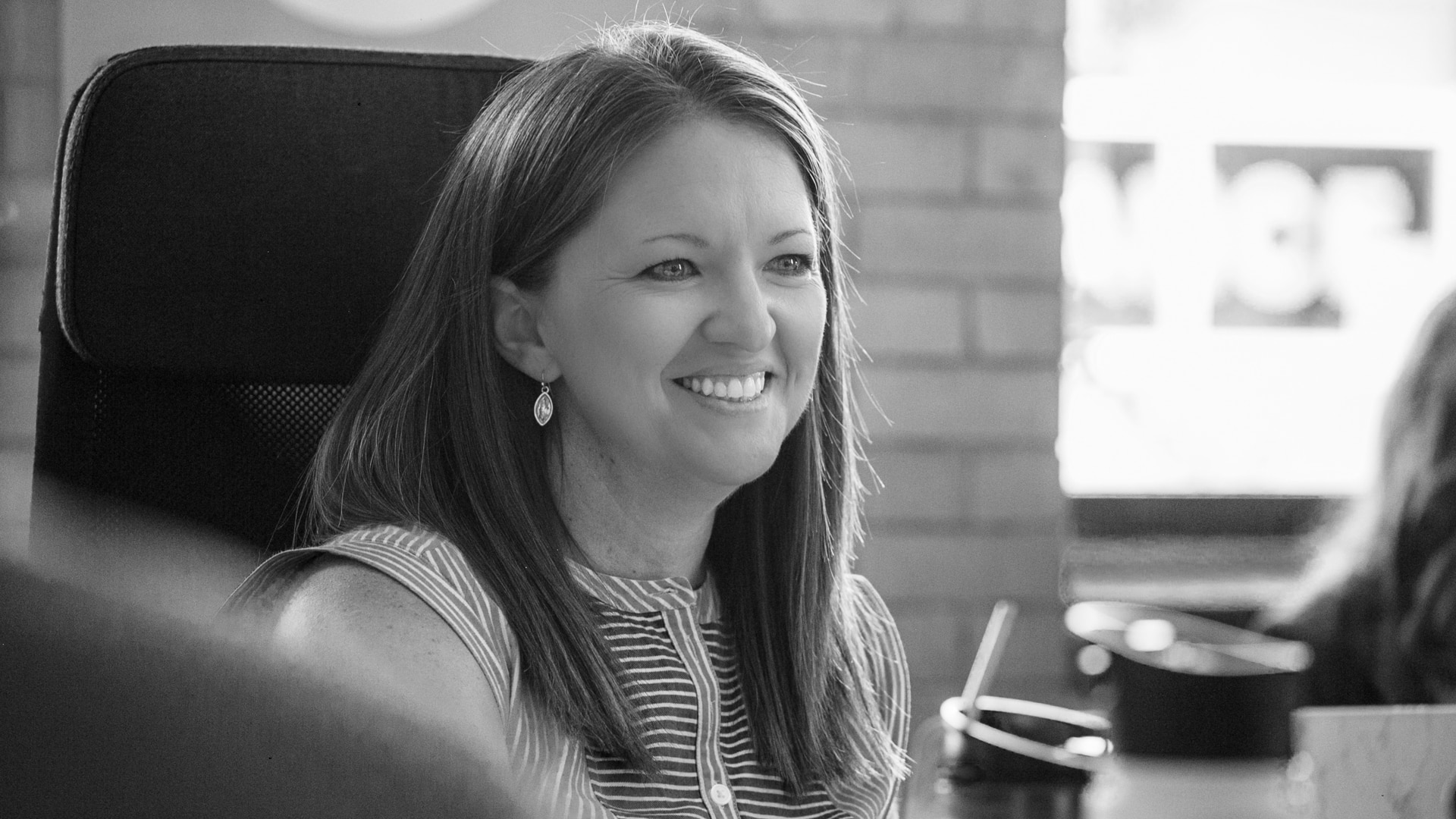 A Koch Comm PR strategist smiling and engaging in a staff meeting.