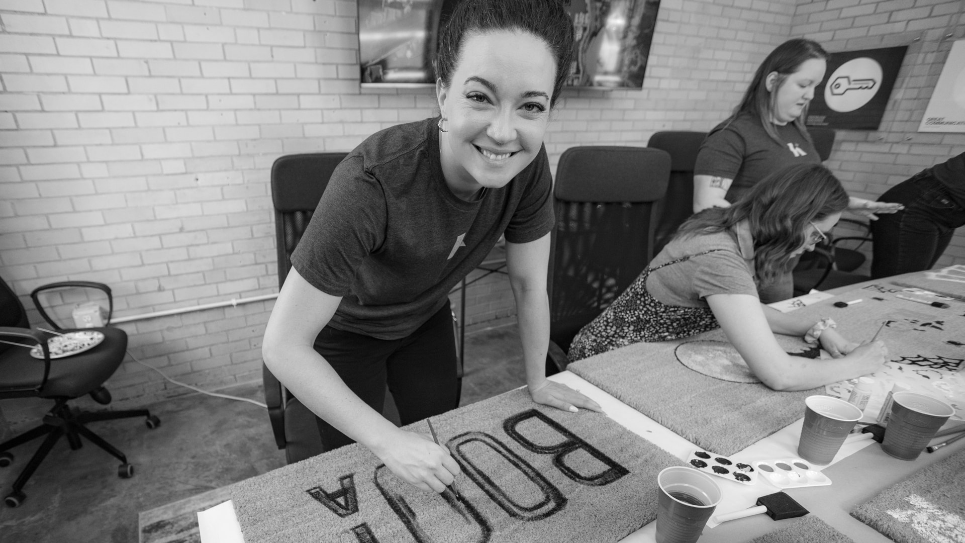 A Koch Comm graphic designer smiling and engaging in a team building craft activity.